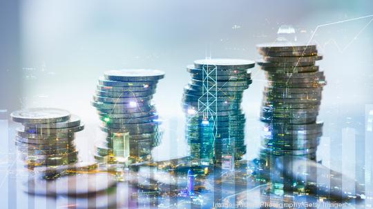 Double exposure of city with graph and stack of coins for finance and business concept