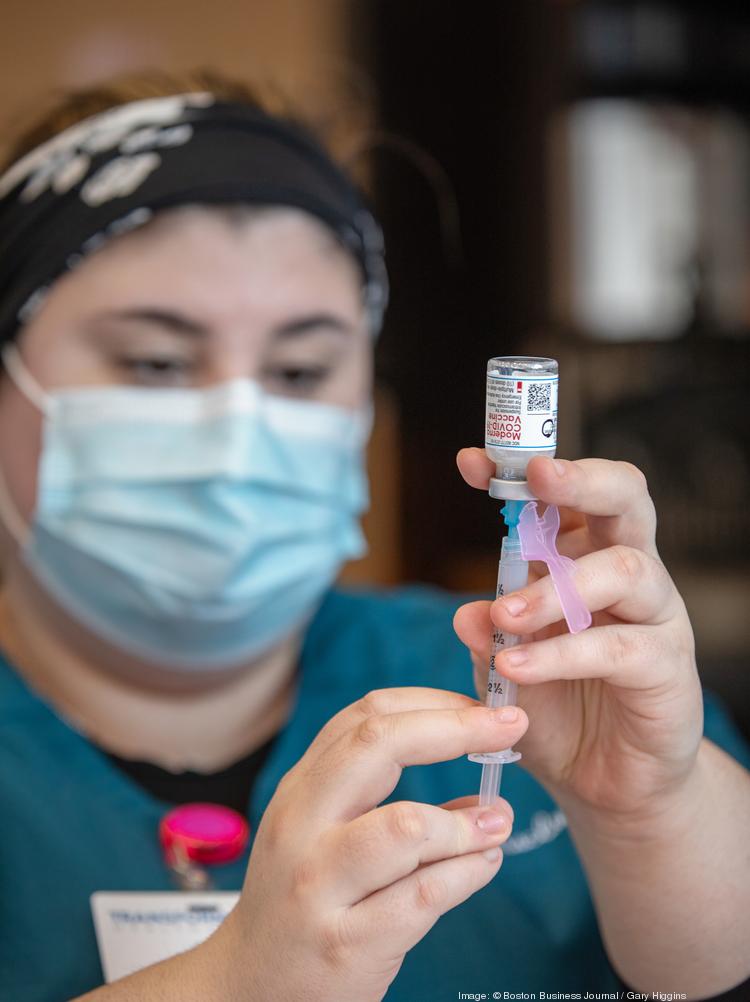 A technician draws Moderna's Covid-19 vaccine from a glass vial into a needle at a state-run vaccination site.