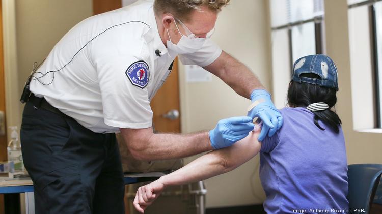 The Seattle Fire Department administers the COVID-19 vaccine to a Seattle resident