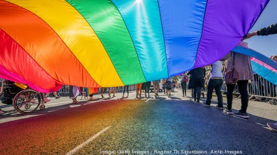 Gay Pride Parade-People marching with a large Flag, Reykjavik, Iceland