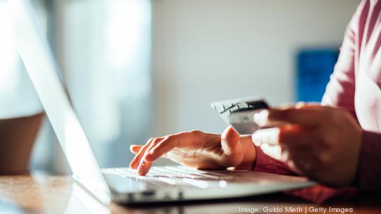 Woman shopping online with a credit card and pc.