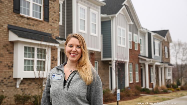 Andi Dirkschneider, vice president of land acquisition and development at Brookline Homes, is pictured with townhomes at Beatty Woods in Belmont.