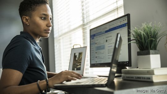 Young woman working on desktop computer at home