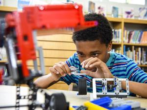 Boy assembling plastic blocks in library