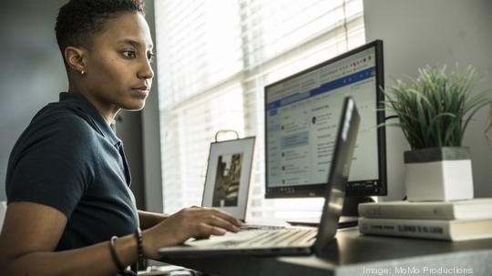 Young woman working on desktop computer at home