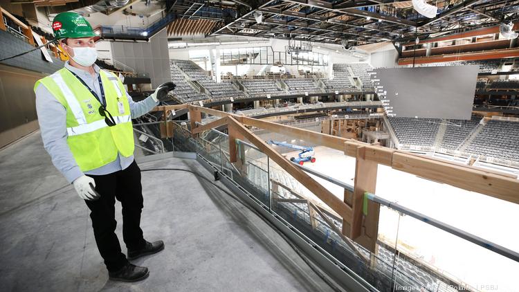 Sam Morgan, director of corporate partnerships for the Seattle Kraken, stands on a loge overlooking the ice during the final phase of construction at Climate Pledge Arena.