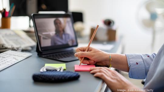 Woman making notes during video call