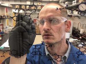 david e. olson phd draws chemical structures on a fume hood