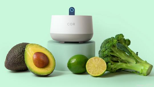 Cor's in-home spectrometer with an avocado limes and broccoli amid a pastel green background