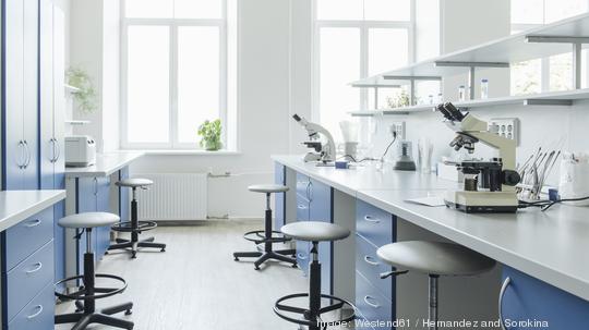 Microscopes at desk in bright empty laboratory