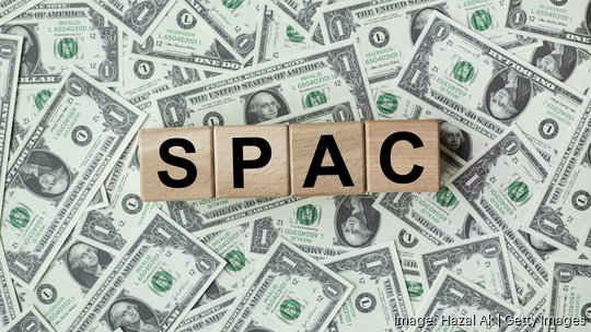 SPAC, special purpose acquisition company symbol. Wooden cubes with word 'SPAC' on beautiful background from dollar bills, copy space. Business and SPAC, special purpose acquisition company concept.