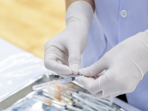 Gloved Hand holding a Syringe