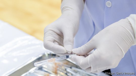 Gloved Hand holding a Syringe