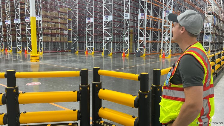 Tom Orr, part of the leadership team at Amazon's new KRB9 facility in Mesa, looks at the empty shelves of the new 1.2 million-square-foot storage and distribution center. Soon the site's shelves will be filled with product from third-party-sellers.