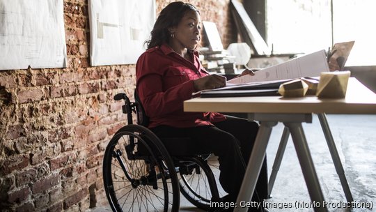 Businesswoman in wheelchair working at desk