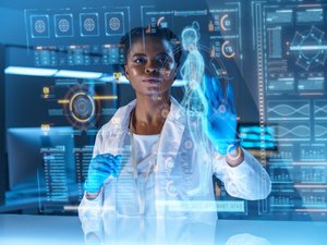 A young African - American doctor works on HUD or graphic display in front of her