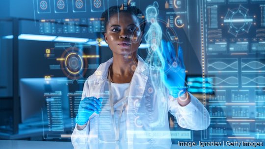 A young African - American doctor works on HUD or graphic display in front of her