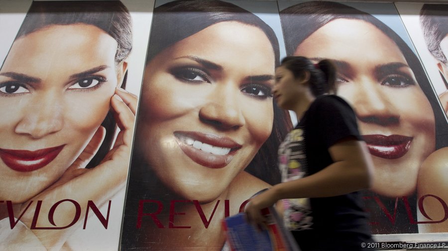 A pedestrian walks past a Revlon cosmetics advertisement in Vientiane ...